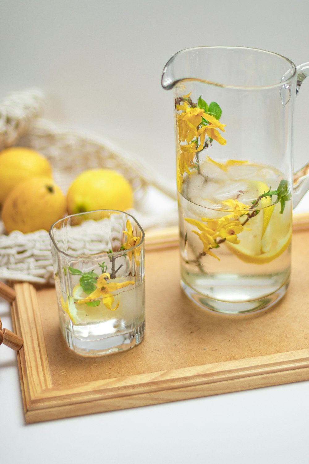 a pitcher of lemonade and a glass of water on a tray