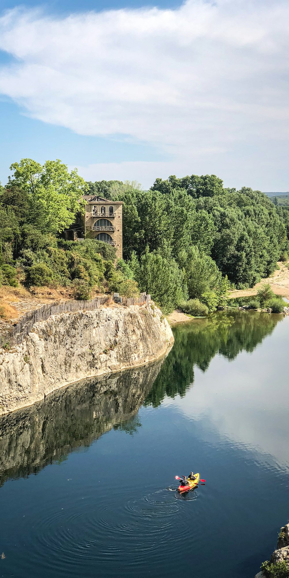 Una persona en un kayak en un río con un castillo al fondo