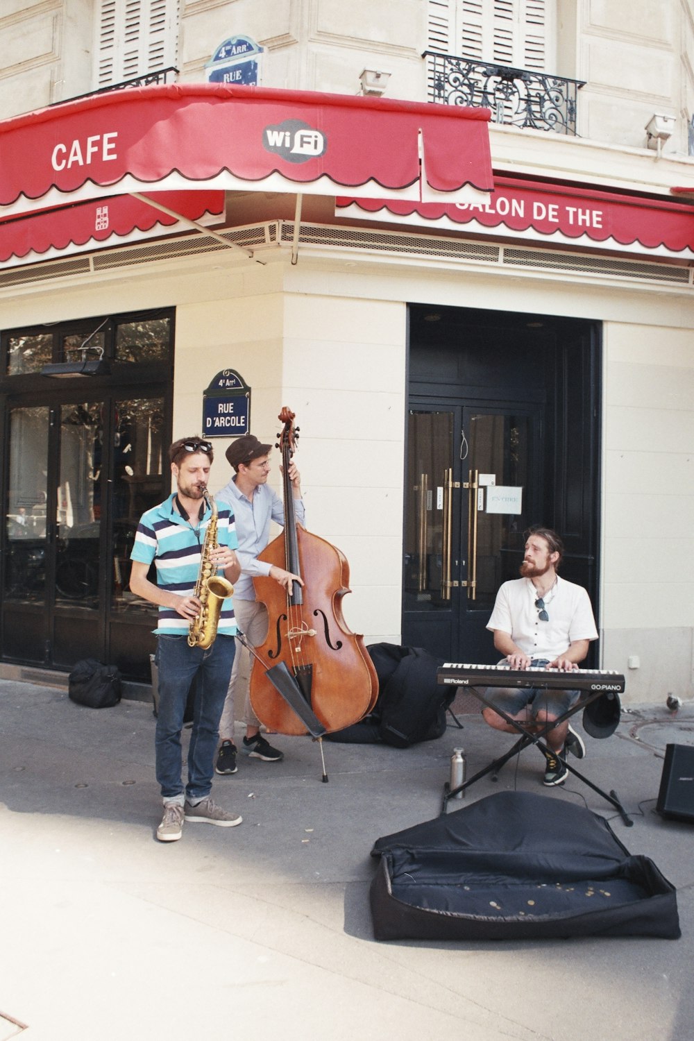 a group of men playing music outside of a cafe