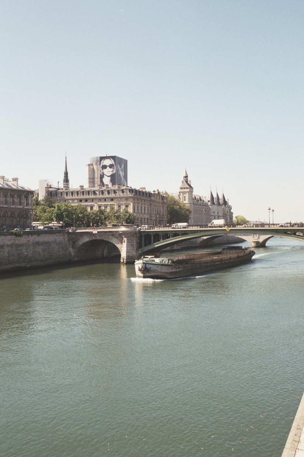 a boat traveling down a river next to a bridge