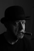 a man with a hat and a cigar in his mouth