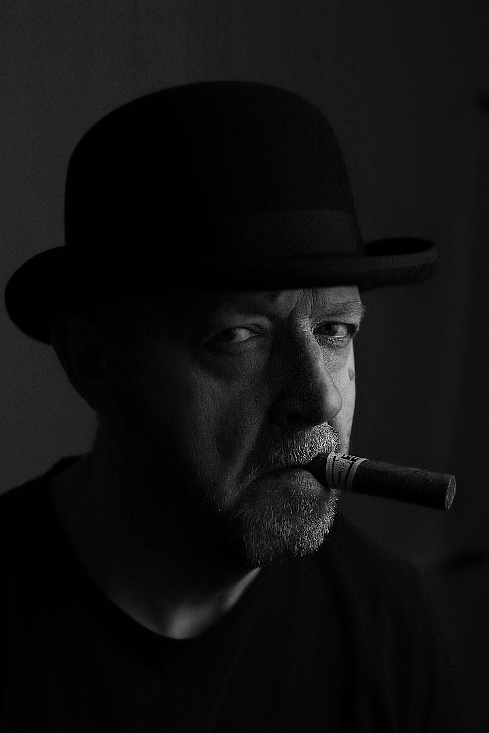 a man with a hat and a cigar in his mouth