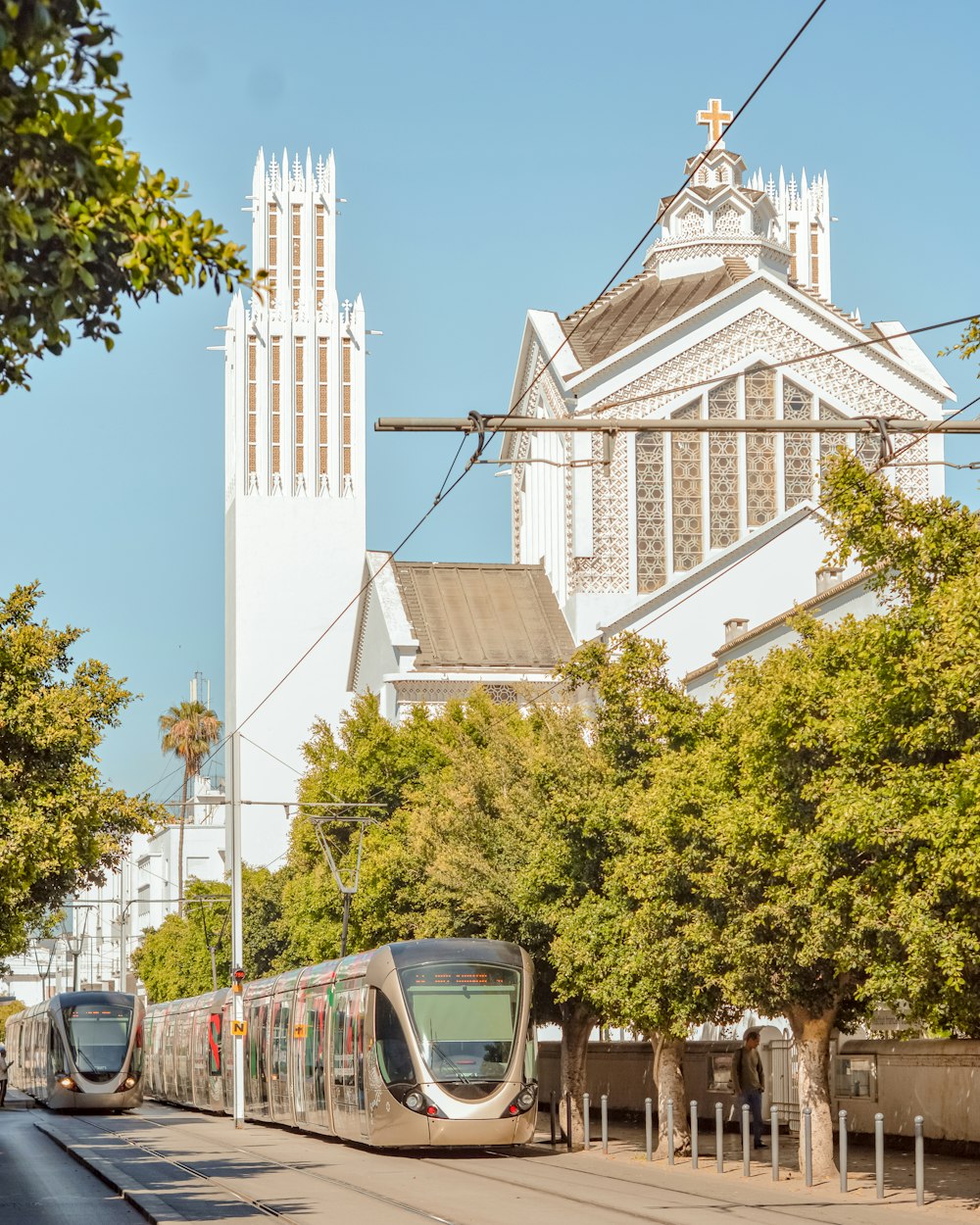 a train on the tracks in front of a church