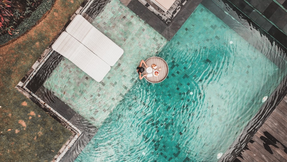 a person sitting on a small boat in a pool