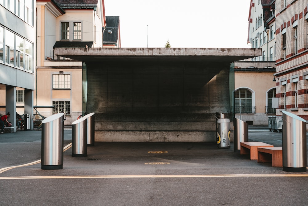 an empty parking garage with benches and trash cans