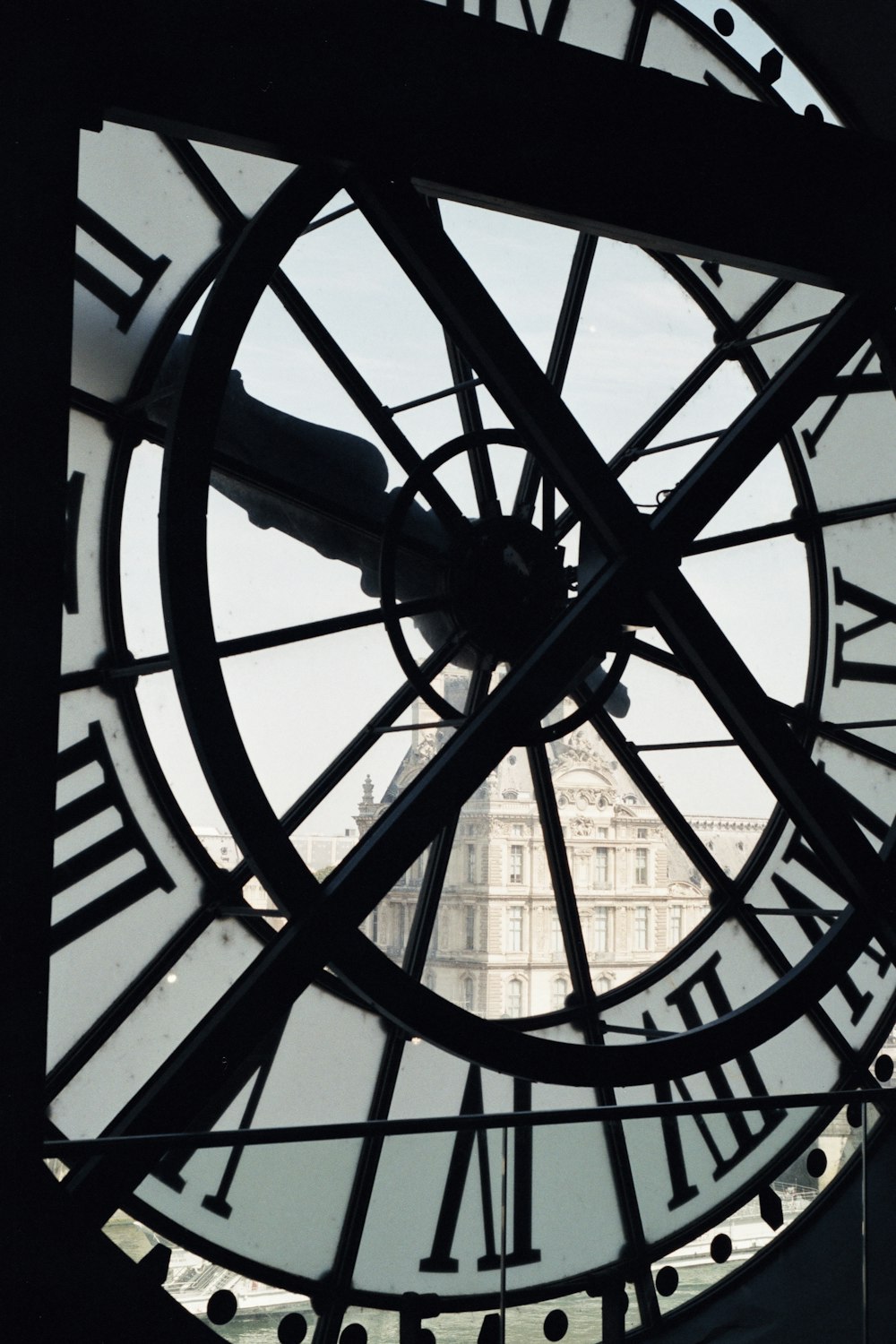 a close up of a clock face with a building in the background