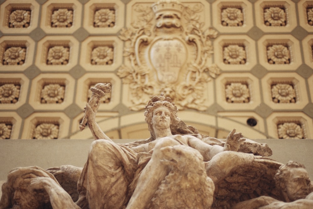 a statue of a woman sitting on top of a pile of rocks