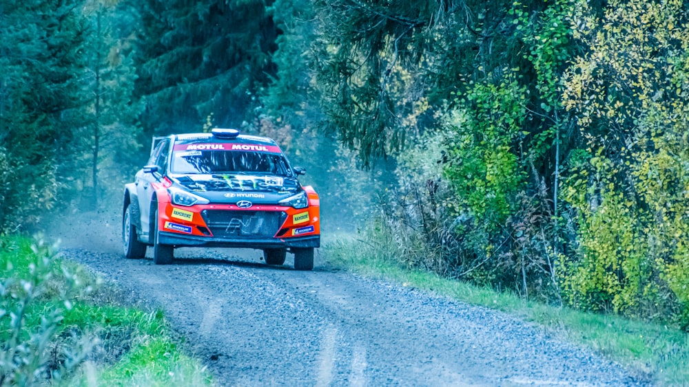 a car driving down a dirt road in the woods