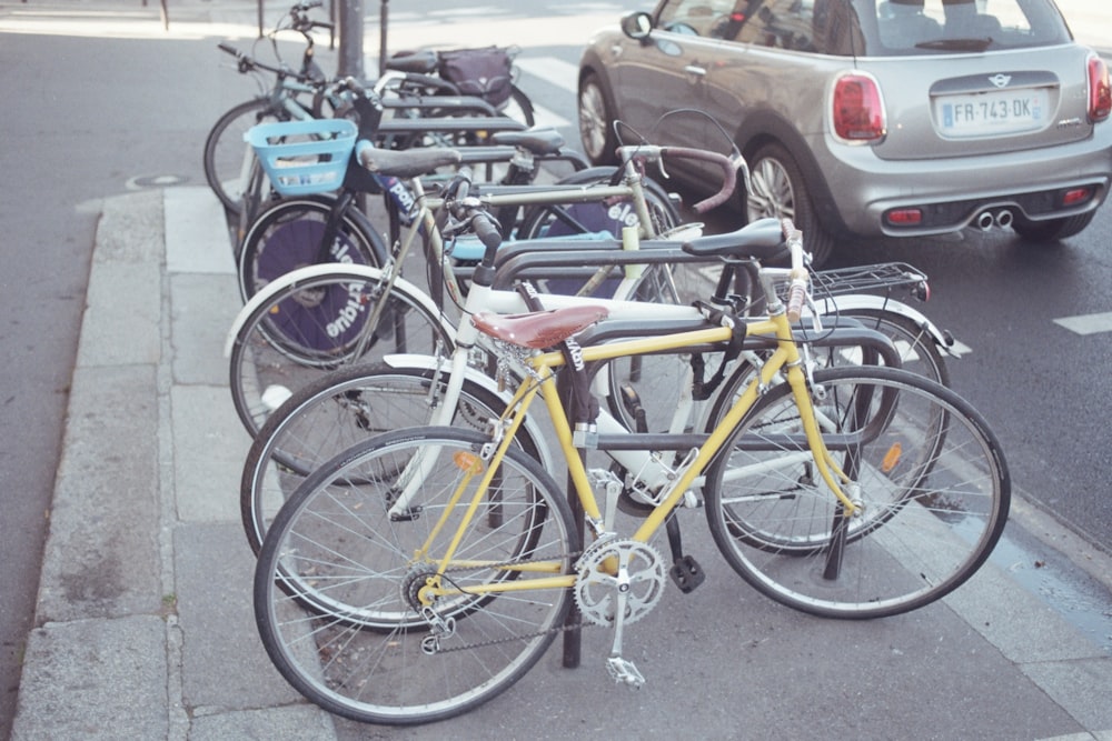 a row of bikes parked on the side of a street
