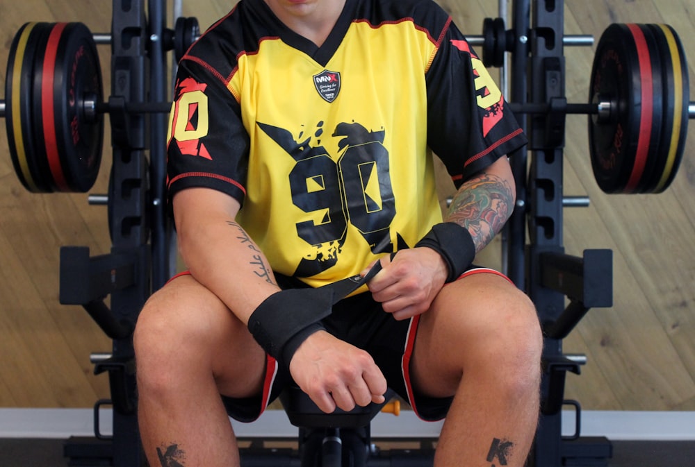 a man sitting on top of a bench in a gym