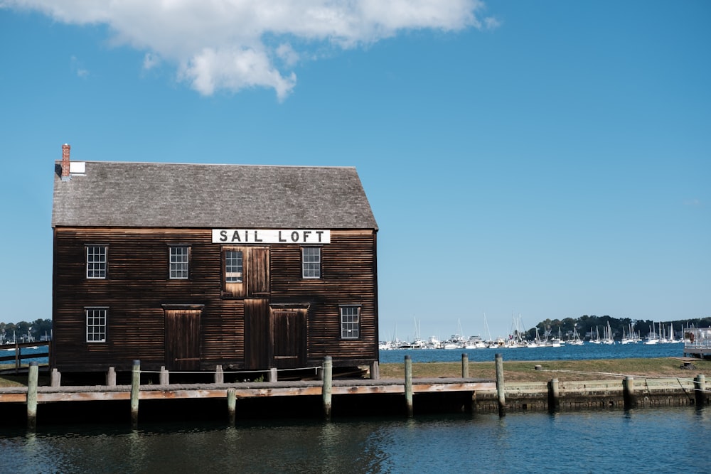 a wooden building sitting on top of a pier next to a body of water