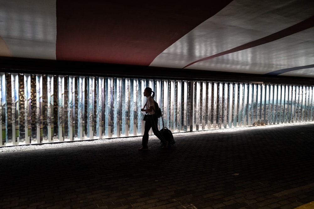 a person with a suitcase walking down a walkway