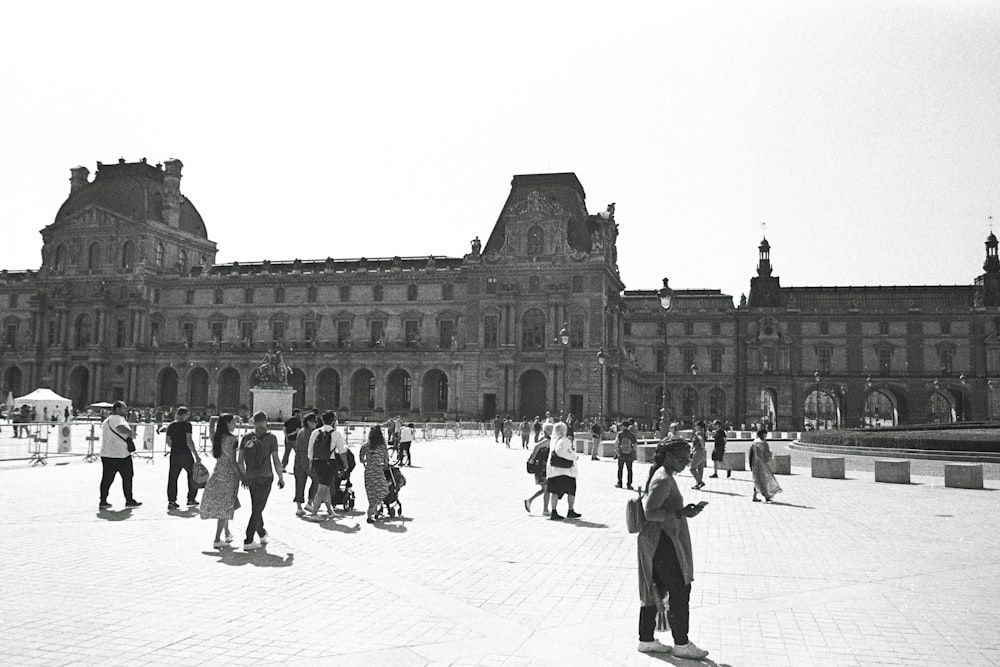 a group of people standing in front of a large building