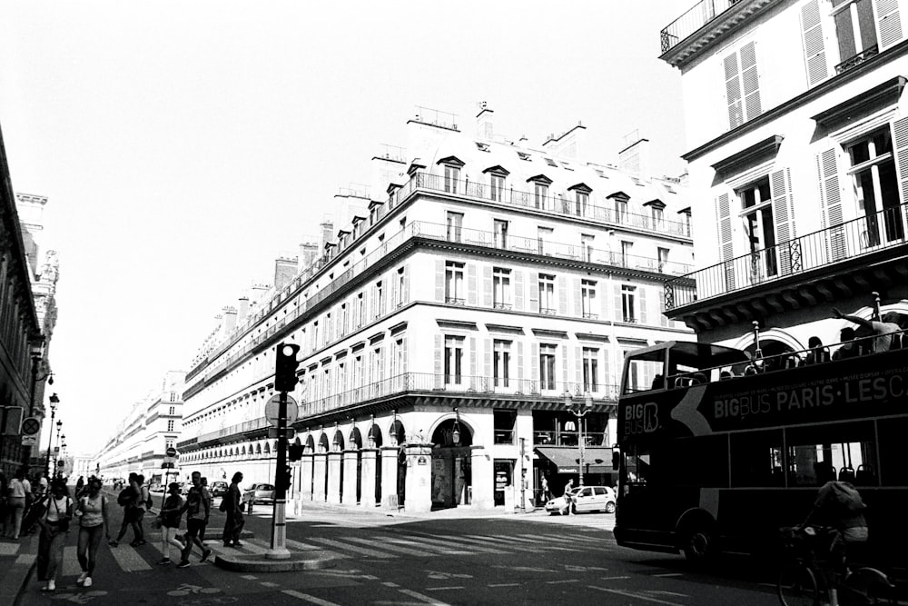 a double decker bus driving down a street next to tall buildings