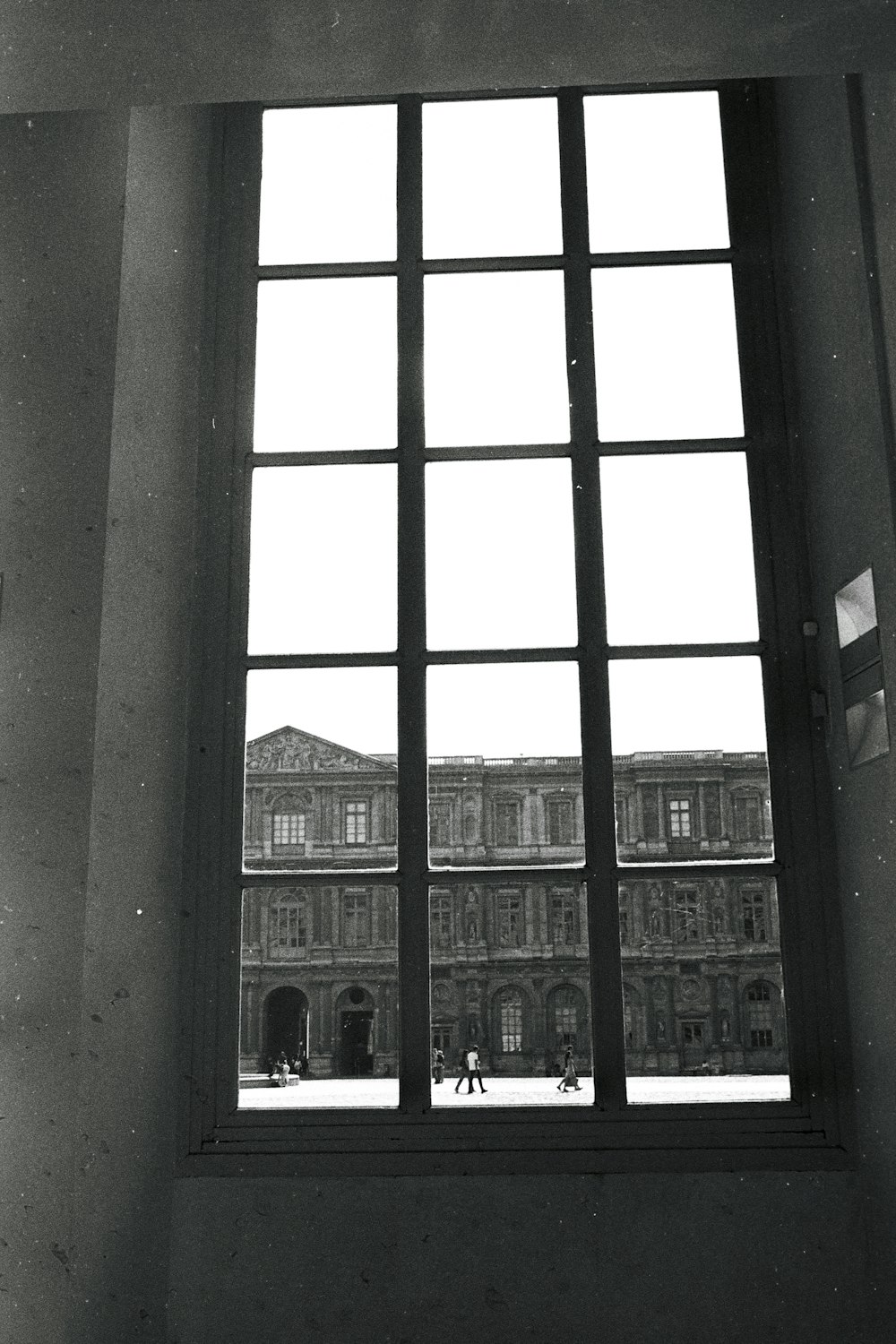 a black and white photo of a building through a window