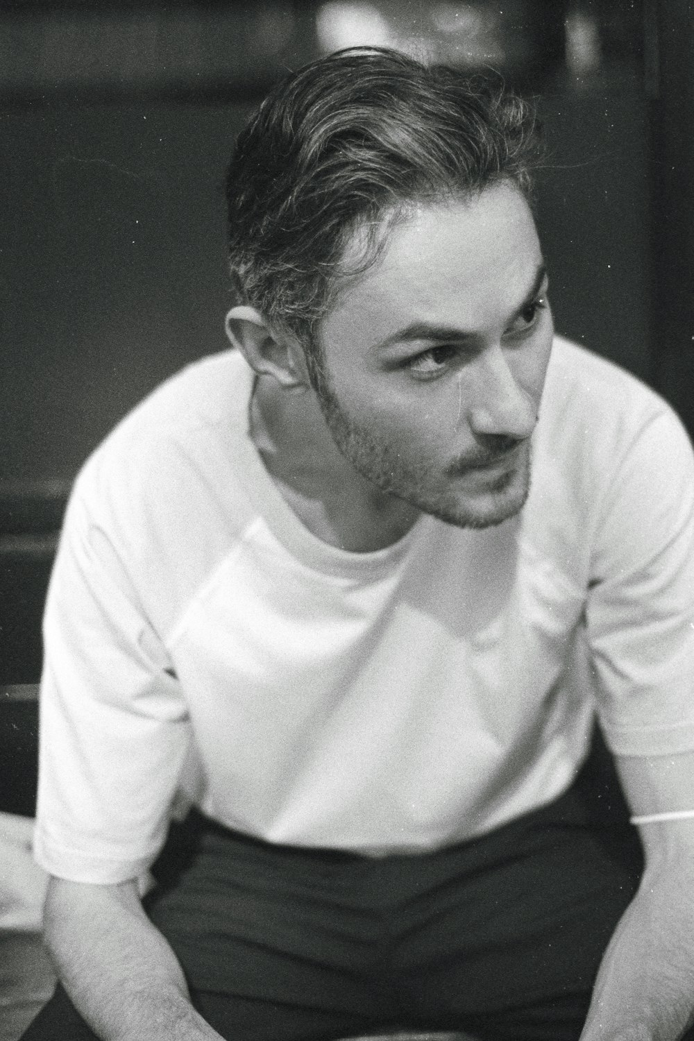 a black and white photo of a man sitting down