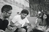 A candid moment of friends chatting animatedly on a sunlit city street.