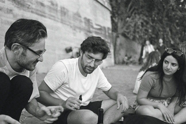 A candid moment of friends chatting animatedly on a sunlit city street.