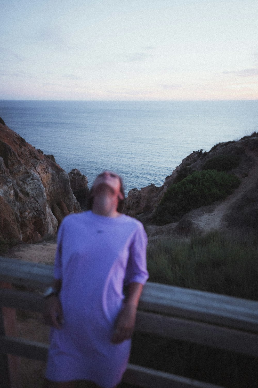 a man standing on a balcony looking at the ocean