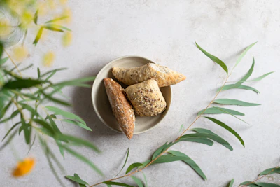 Freshly baked bread buns and sandwiches served on a handcrafted ceramic plate.