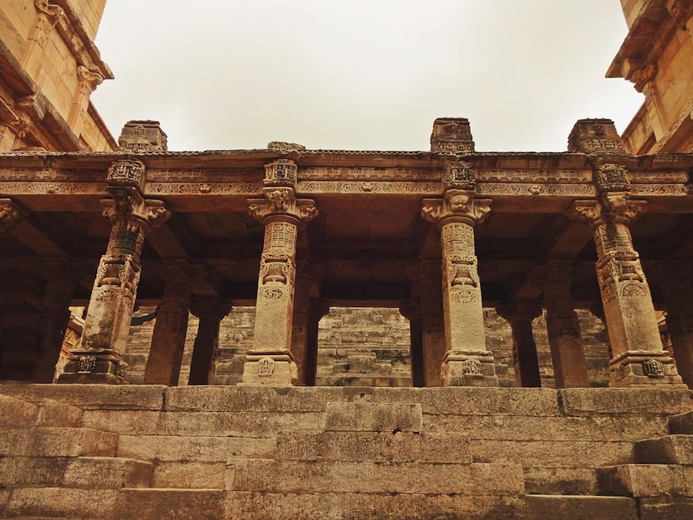 a stone building with columns and a sky background