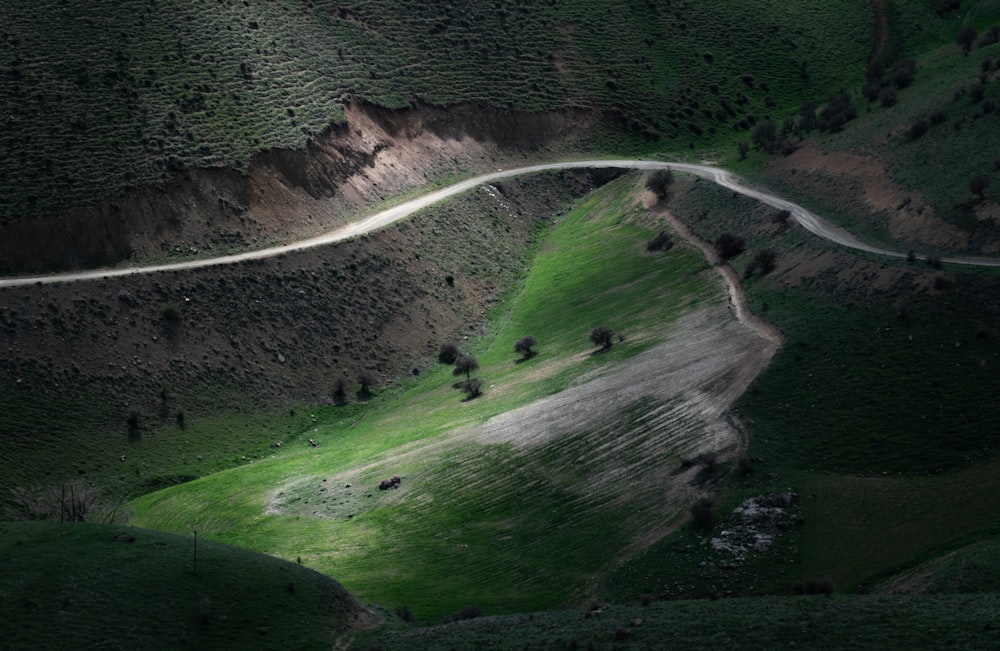 a winding road winding through a lush green valley