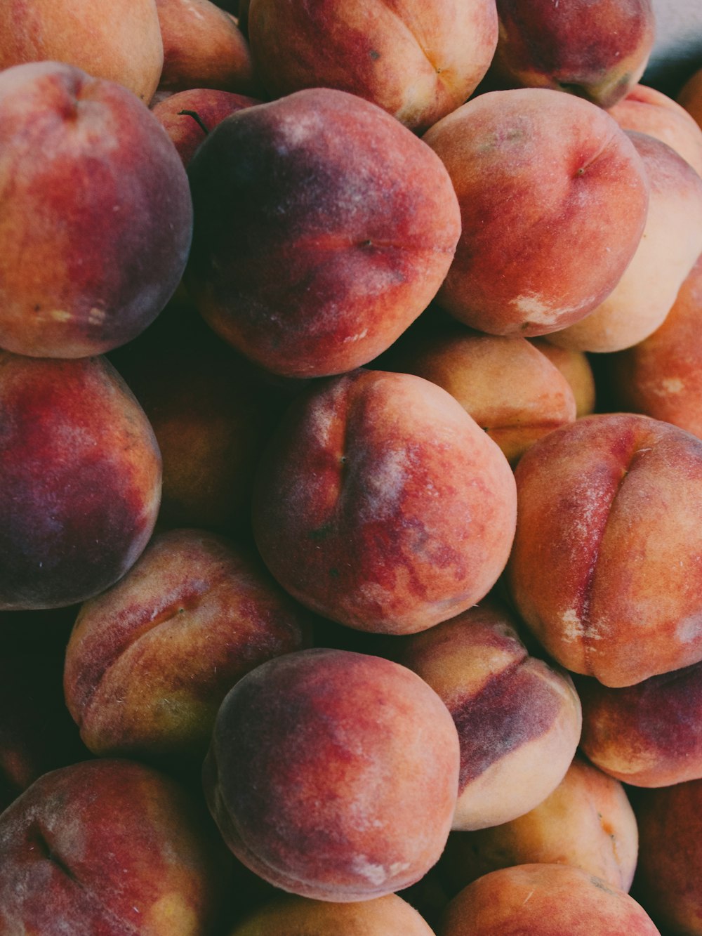 a pile of peaches sitting on top of each other
