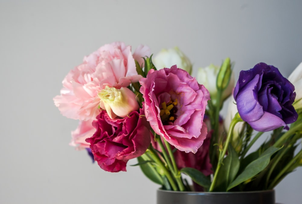 a vase filled with different colored flowers on top of a table