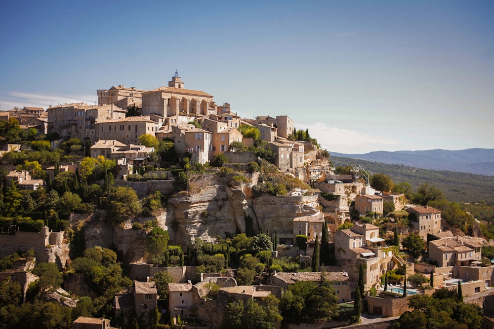 a village on top of a hill surrounded by trees