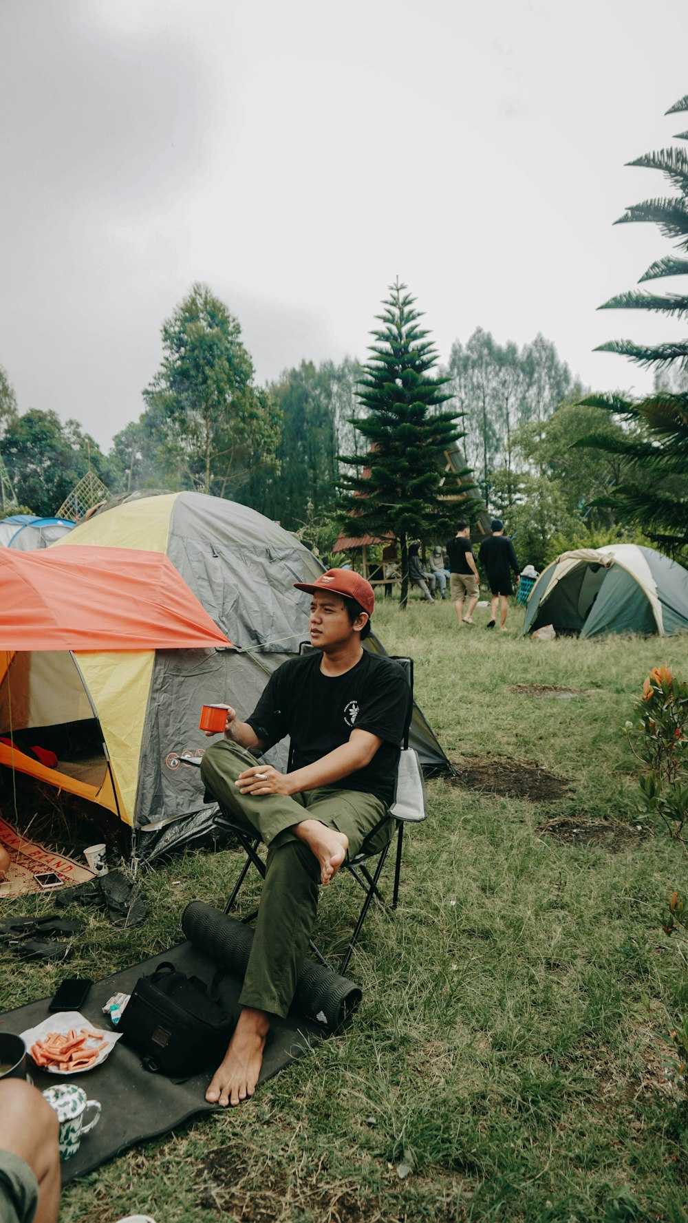 a man sitting in a chair next to a tent