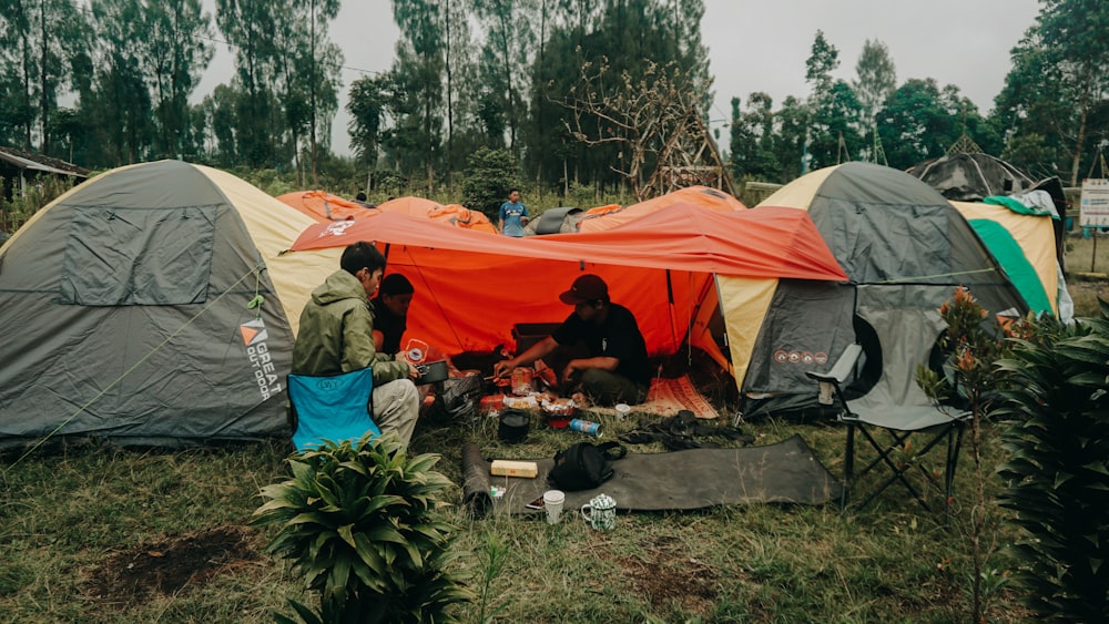 a group of people sitting outside of tents