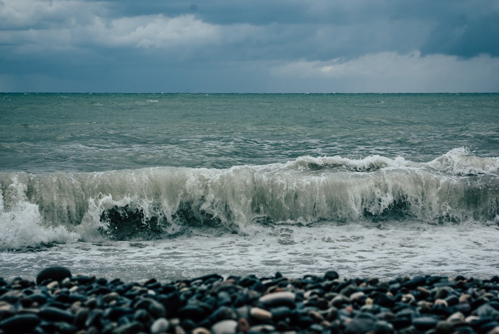 a large body of water sitting next to a rocky beach