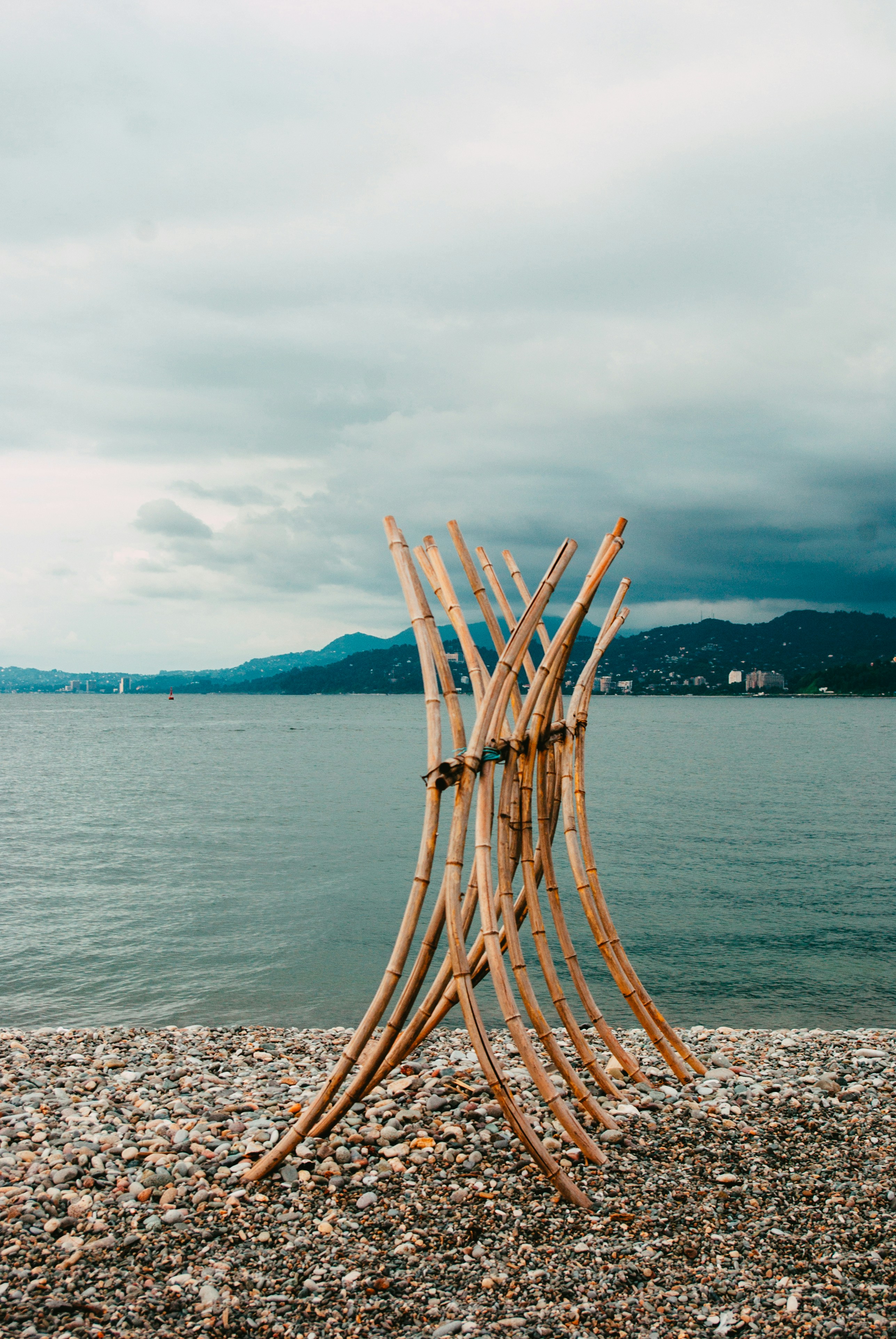 a sculpture made out of sticks on a beach
