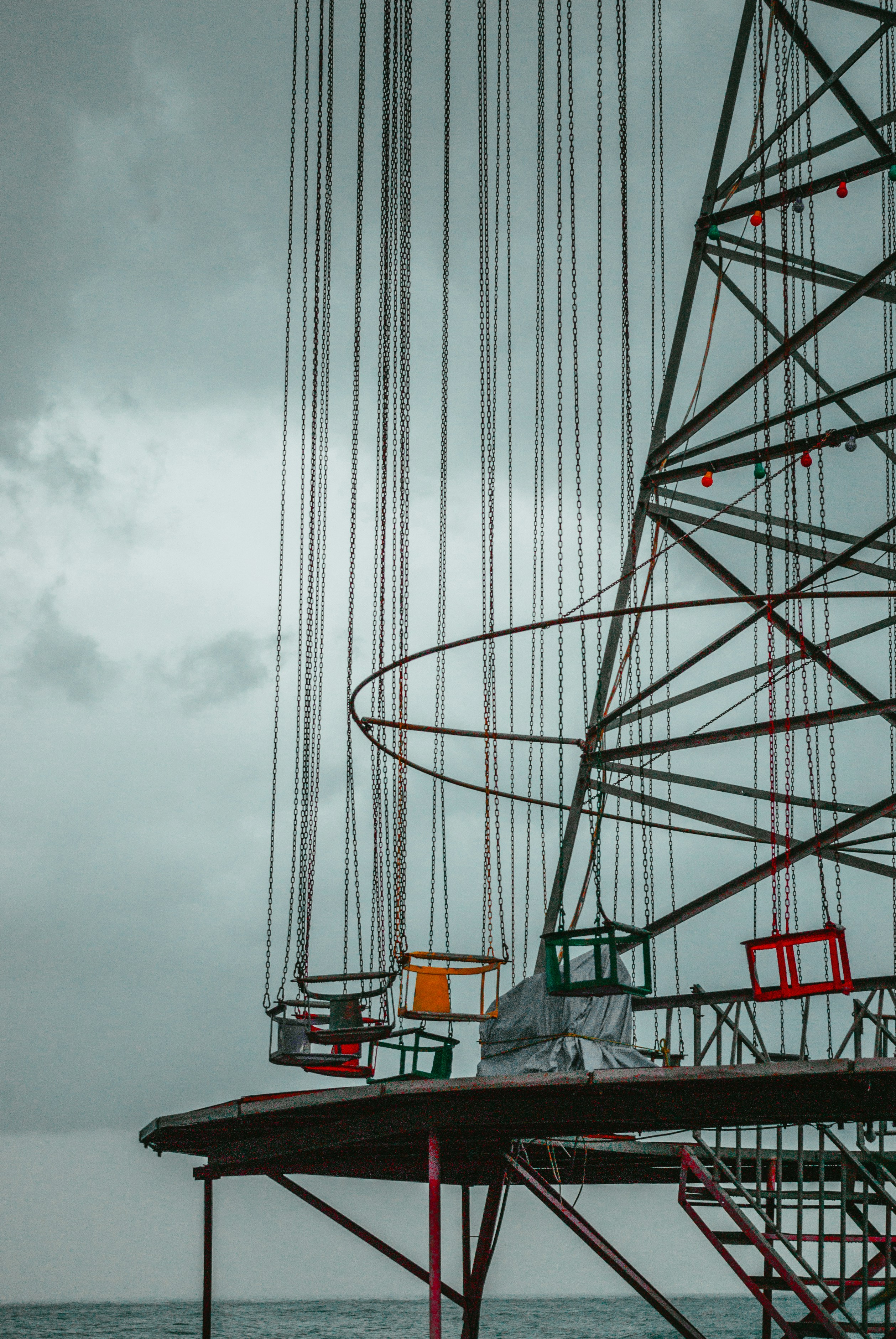 Une grande roue posée au sommet d’une jetée au bord de l’océan