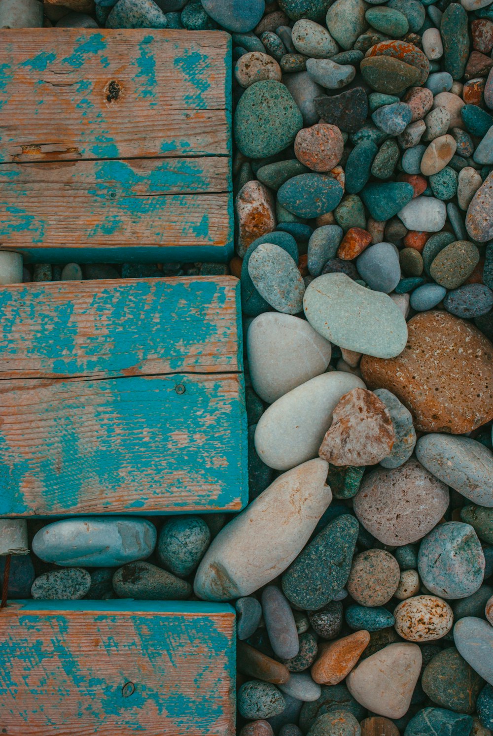 a wooden bench sitting on top of a pile of rocks