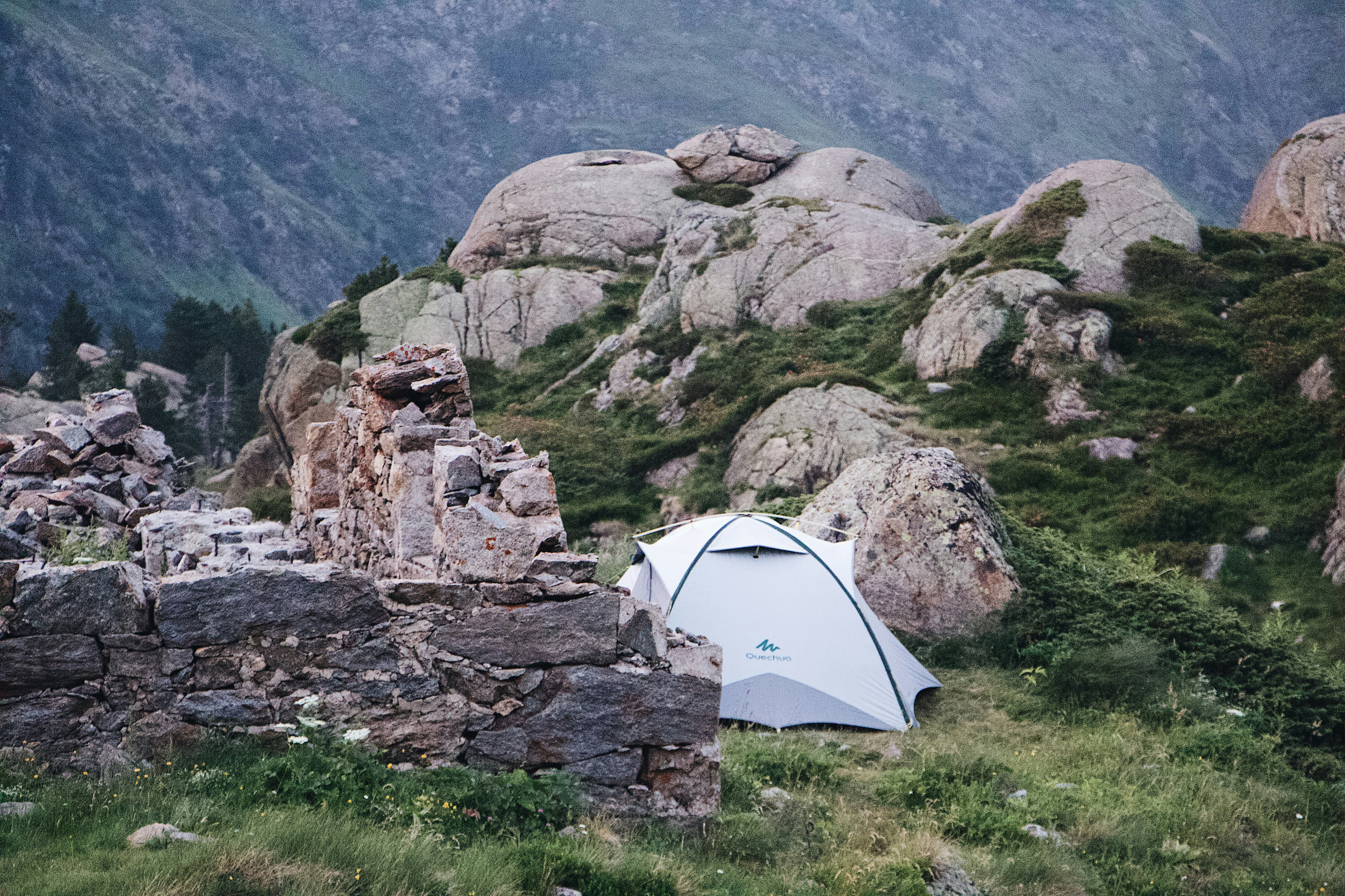 a tent pitched up on a rocky hillside