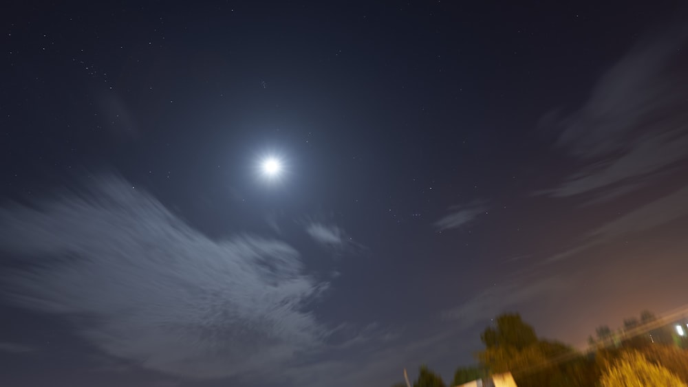 a bright moon shines in the night sky