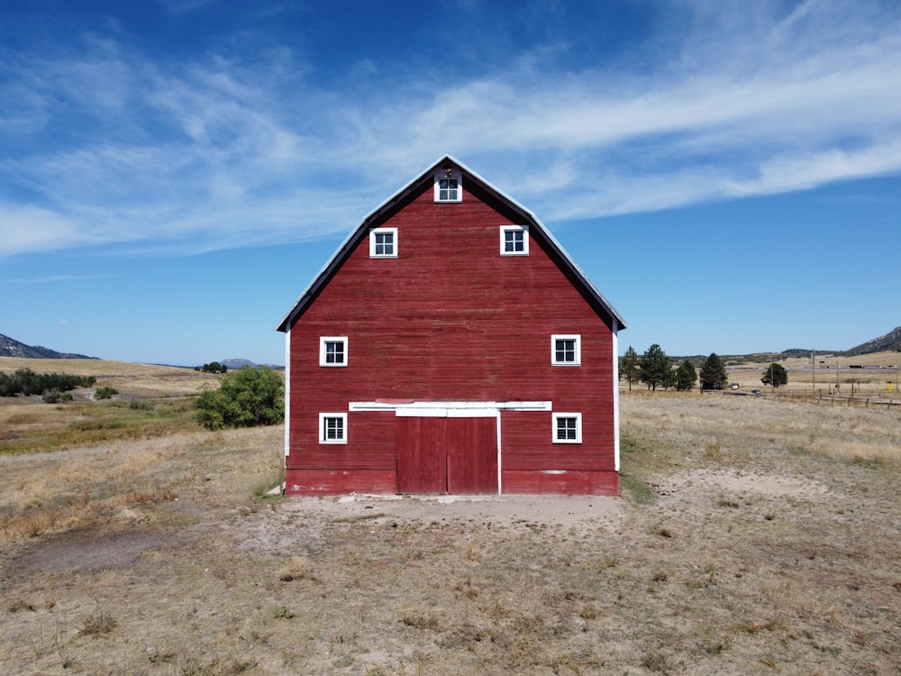 a red barn with a white door and windows