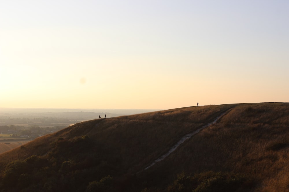 Un couple de personnes debout au sommet d’une colline