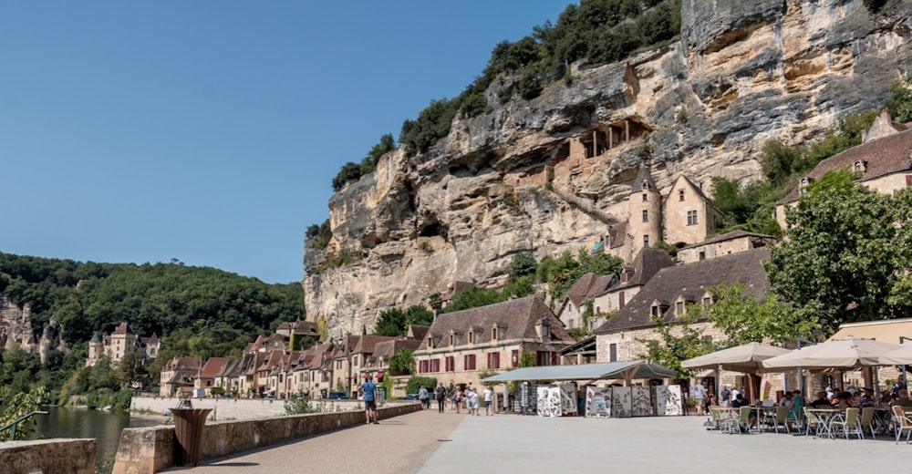 a group of people walking down a street next to a cliff