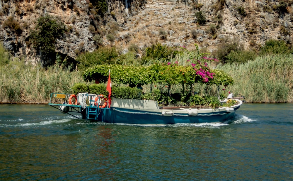 un bote con plantas en la parte posterior de él en un cuerpo de agua