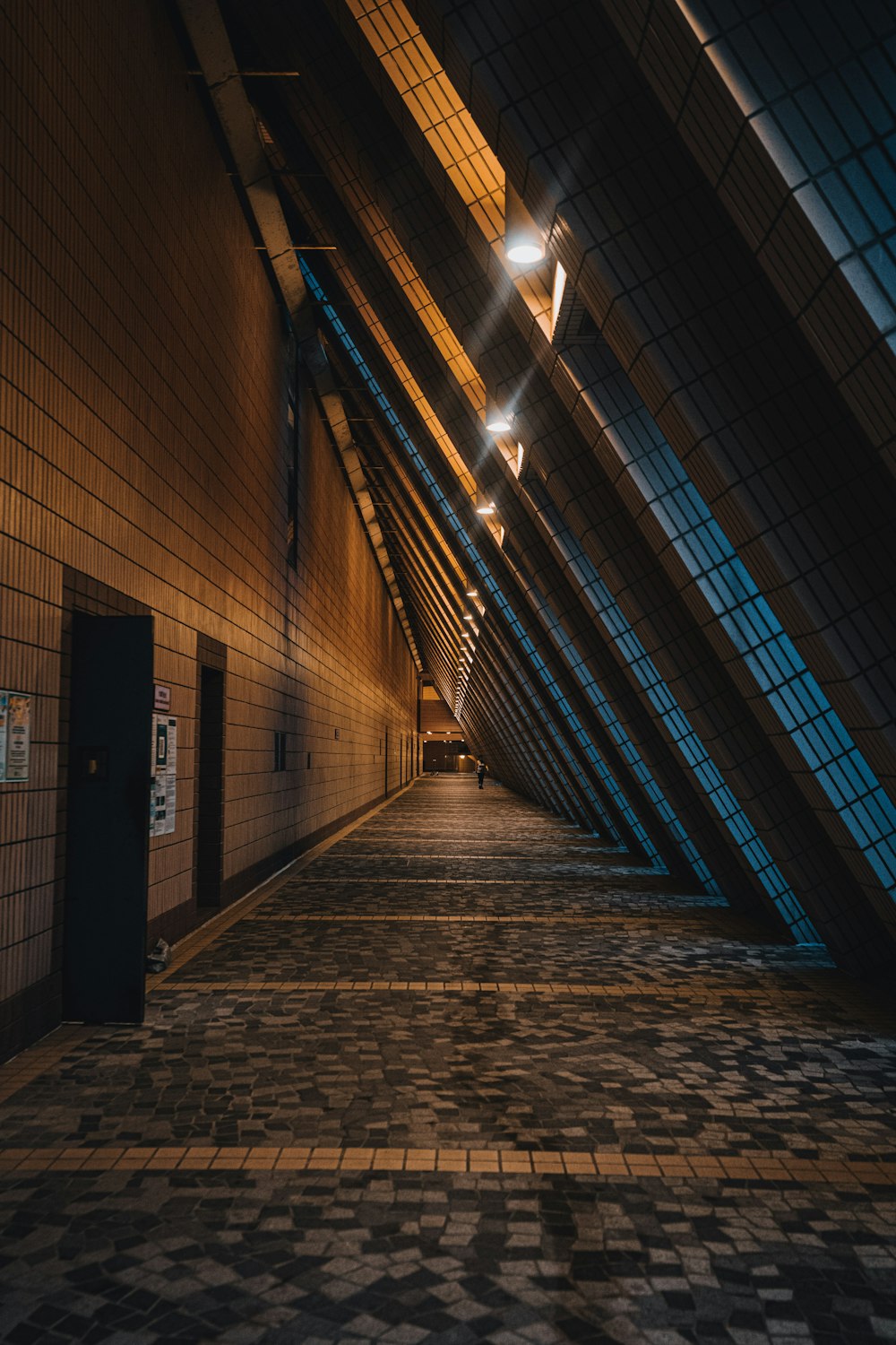 a long hallway with a tiled floor and a skylight