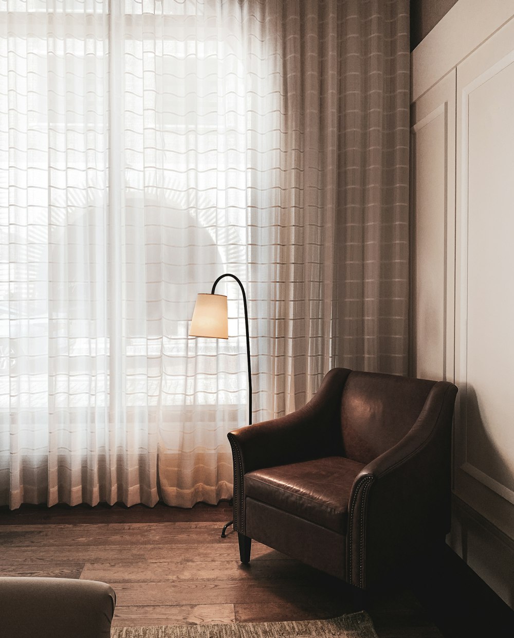 a living room with a chair and a lamp