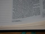 The image shows a close-up of a page from a book, specifically a biblical text. The text discusses Solomon accumulating chariots and horses. There are footnotes at the bottom of the page detailing additional information.