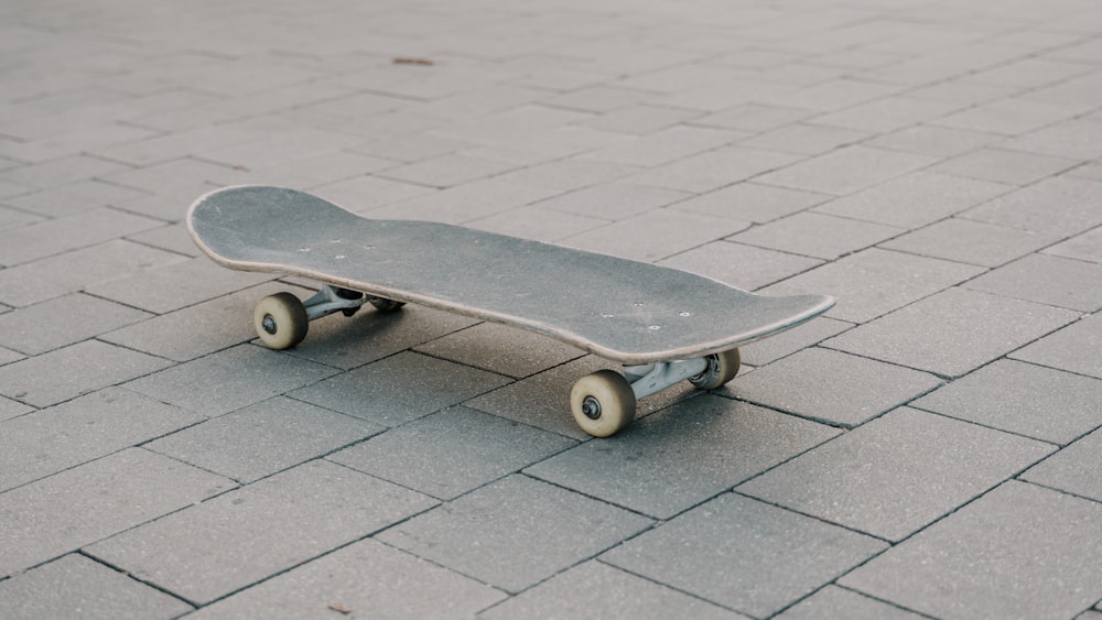 a skateboard is sitting on a brick sidewalk