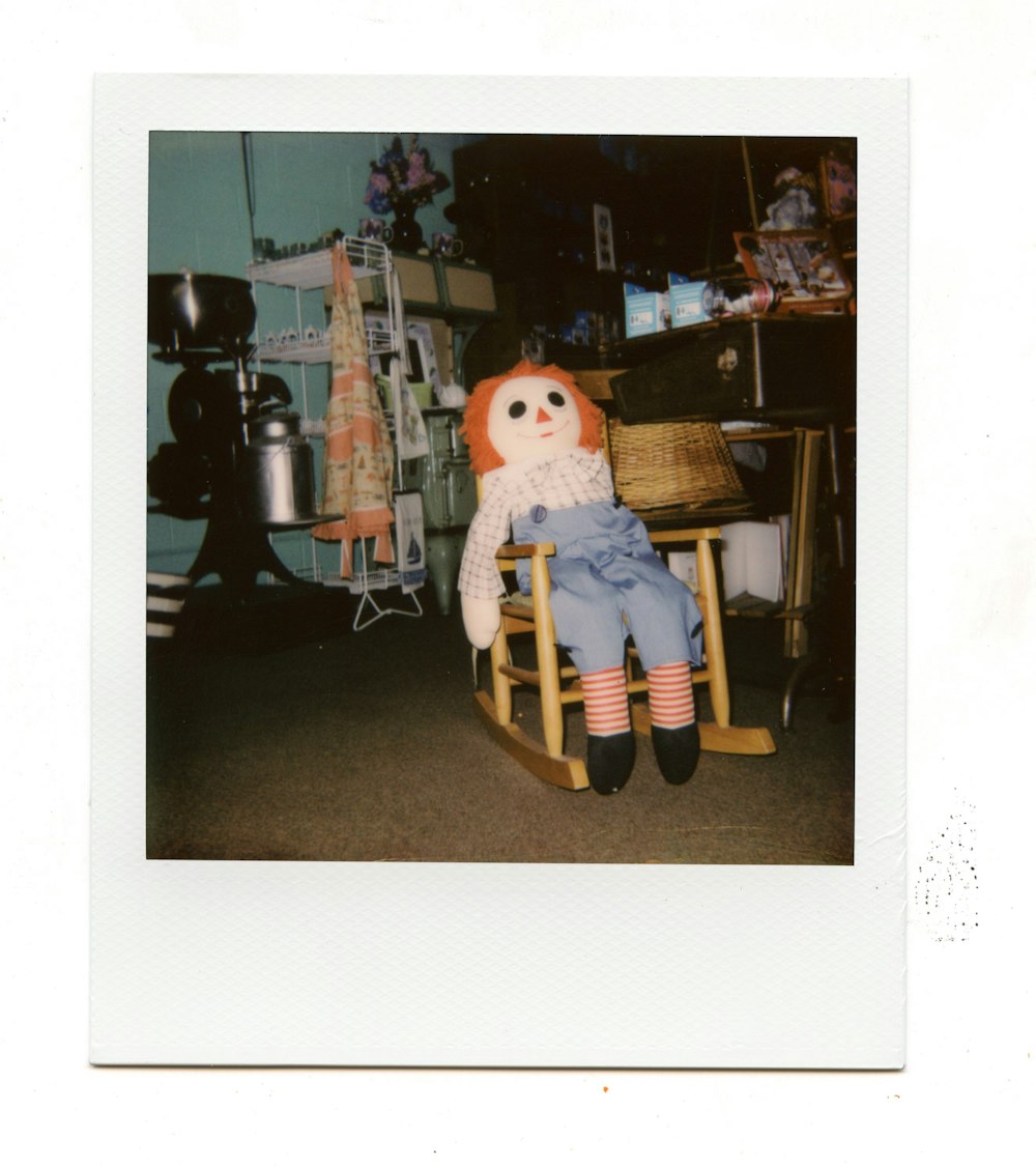 a teddy bear sitting on a rocking chair in a room