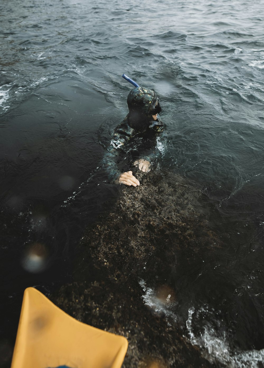 a man in a wet suit swimming in a body of water