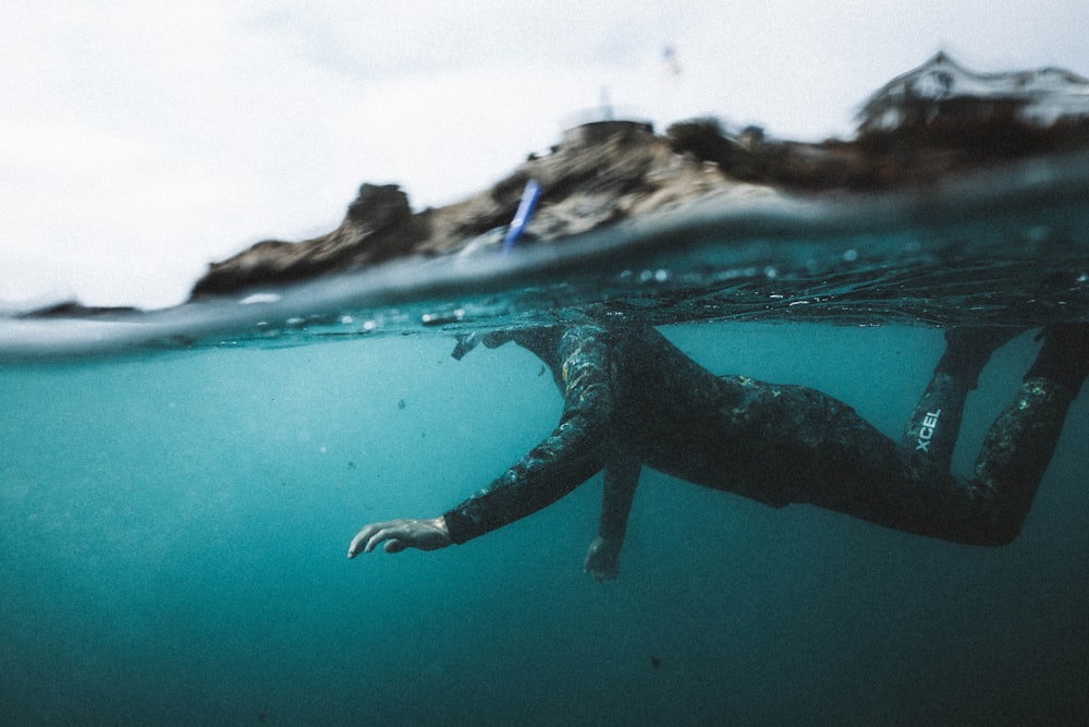 a person swimming in the ocean with a camera attached to a pole