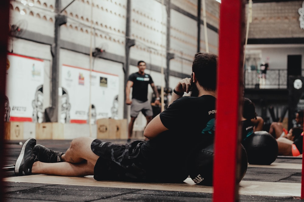 a man sitting on the ground while talking on a cell phone