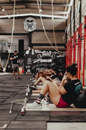 a group of people sitting on the ground in a gym